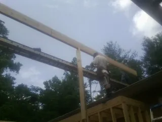 Carpenter setting a ridge beam over a new addition frame — Ice Dam Removal by Roofing Brothers in South Weymouth