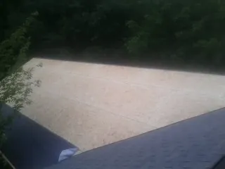 New OSB roof sheathing installed beside an existing shingle roof in South Weymouth