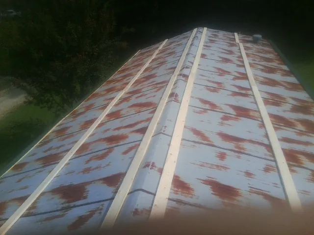 Rusted metal roof panels with new wood purlins before replacement — Storm Damage Roof Repair in South Weymouth by Roofing Brothers
