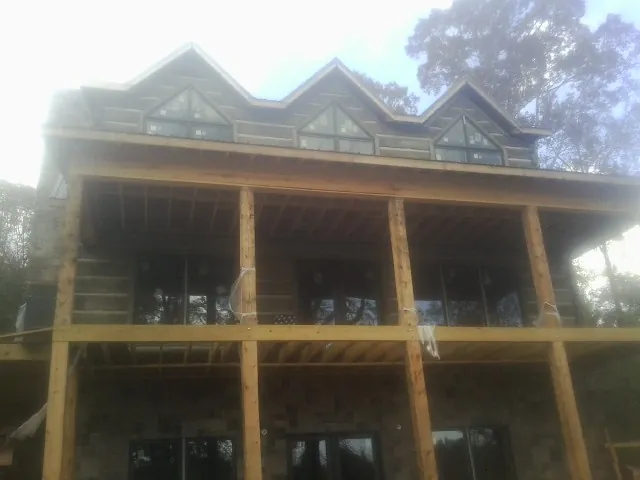 Dormers and porch framing on a large log home under construction — Roof Coating work by our crew in South Weymouth
