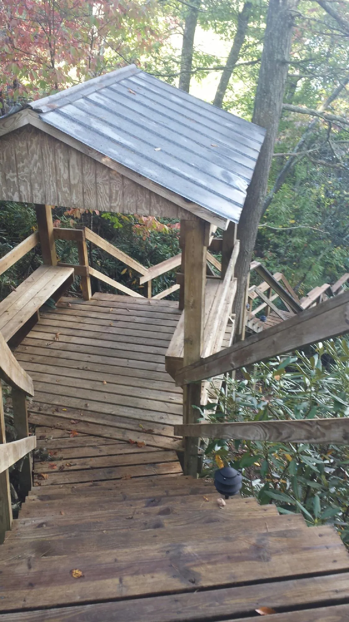 Metal roofed shelter over wooden steps on a wooded walkway — Skylight Repair & Installation work by our crew in South Weymouth