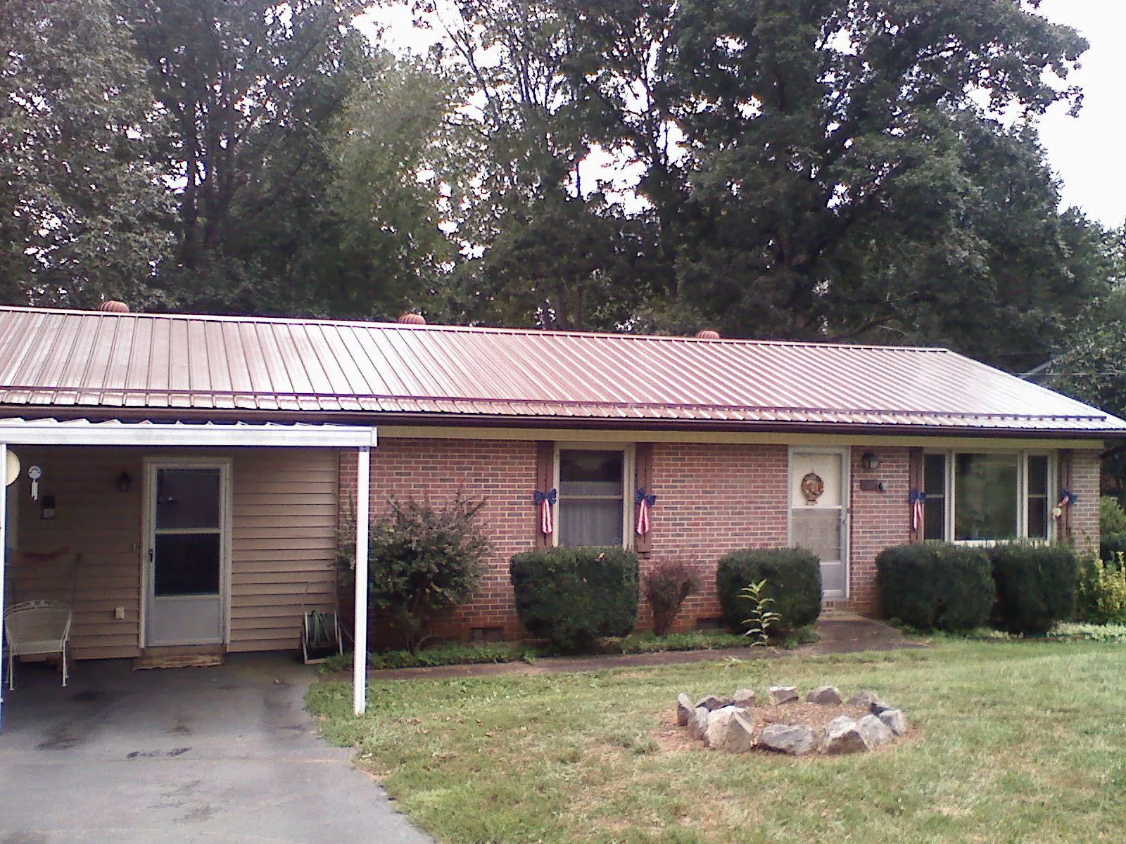 Bronze metal roof and carport on a brick ranch home — Roof Repair work by our crew in South Weymouth